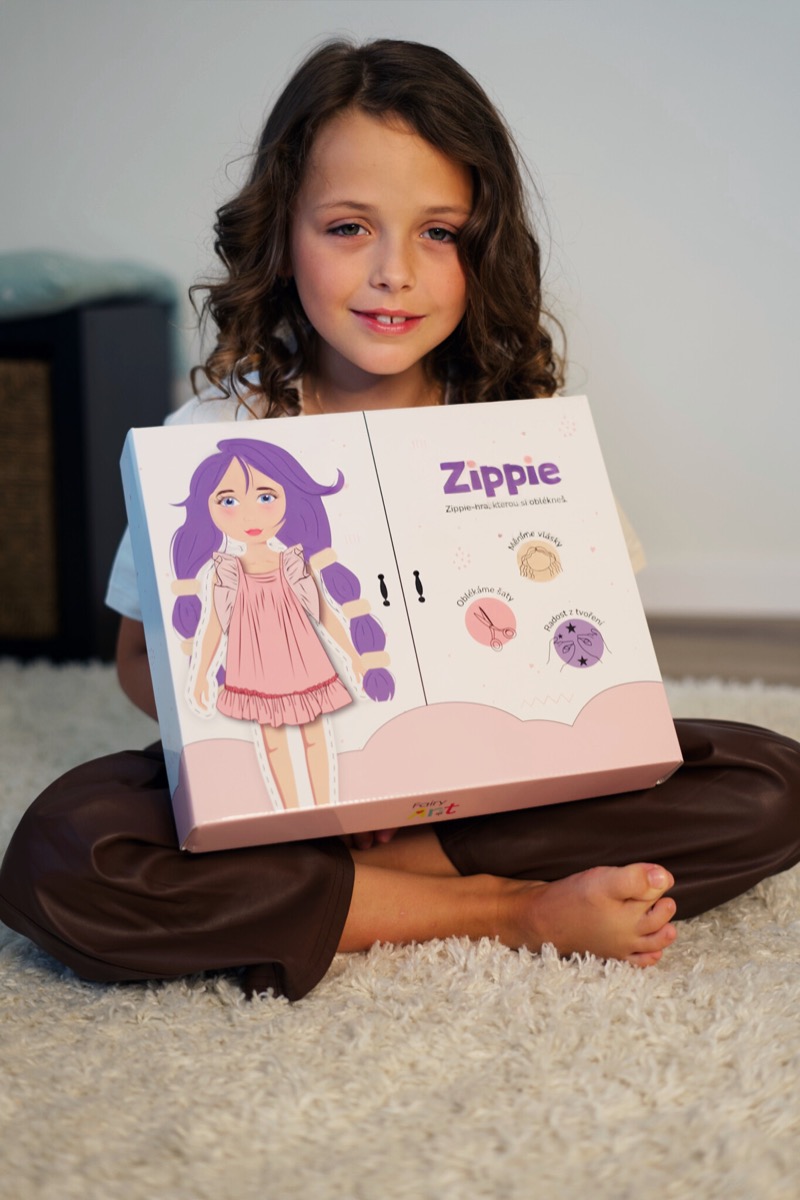 Holčička sedí na koberci a Zippie Box